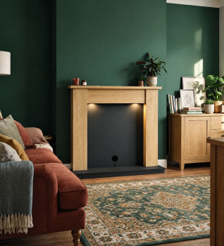 Flare Barrowden fireplace suite in natural oak effect with anthracite hearth and back panel, styled without a fire in a green living room.